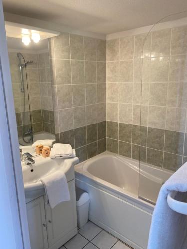 een badkamer met een bad, een toilet en een wastafel bij Vue Sur Green in Levernois