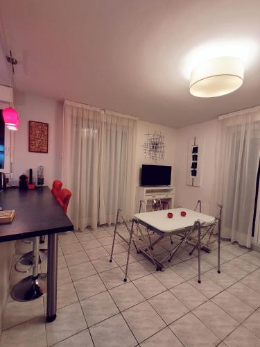 un salon avec une table et une télévision dans l'établissement Duplex Art Place, Olympics 2024, à Les Clayes-sous-Bois