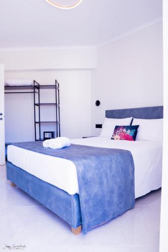 a bedroom with a large bed with a blue blanket at Anemoami in Karpathos