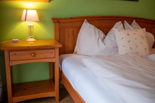 a bedroom with a bed and a nightstand with a lamp at Residence Obermoarhof - Family Apartments with Pool & Playground in Vandoies
