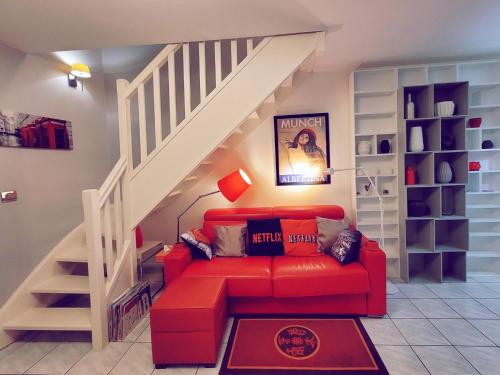 - un salon avec un canapé rouge et des escaliers dans l'établissement Duplex Art Place, Olympics 2024, à Les Clayes-sous-Bois