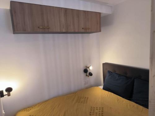 Un dormitorio con una cama con cabecero de madera. en Studio à 100 m de la plage PIQUOT 44, en Granville