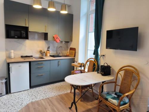 cocina con mesa, sillas, mesa y barra en Studio à 100 m de la plage PIQUOT 44, en Granville