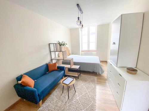 a living room with a blue couch and a bed at Studio coeur de ville paisible in Alençon