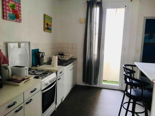 Il comprend une cuisine équipée d'une cuisinière et d'un évier. dans l'établissement Charmant appartement proche de la rue Saint Jean, à Le Touquet-Paris-Plage