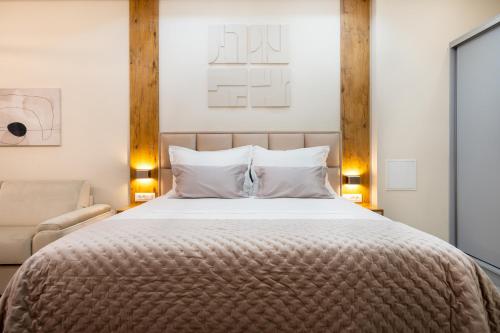 a bedroom with a large bed and a chair at Apartmani Laguna in Neum
