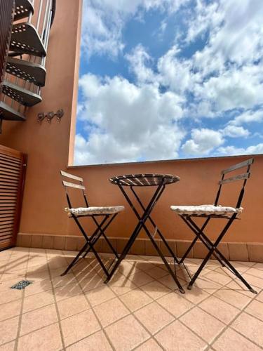 two chairs and a table on the side of a wall at Nura's - Casa Le Ginestre in Alghero