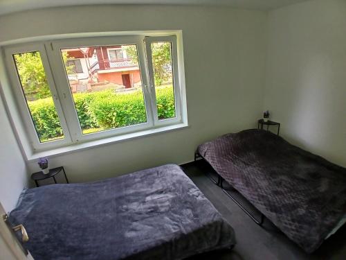 a room with two beds and a window at Domki Pietrowice in Pietrowice