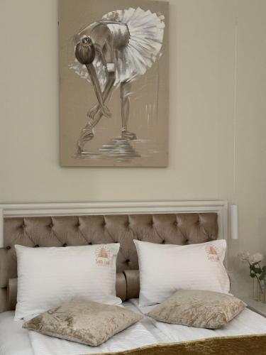 a bed with a black and white picture above it at Apartman Modena Novi Sad in Novi Sad
