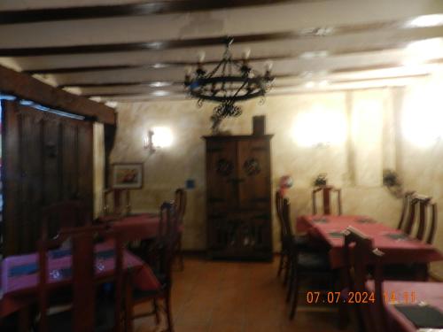 a dining room with tables and chairs and a chandelier at Hotel Rural Papasol in Atapuerca