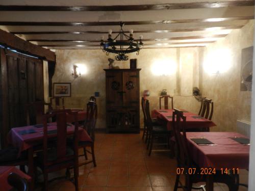 a dining room with tables and chairs and a chandelier at Hotel Rural Papasol in Atapuerca