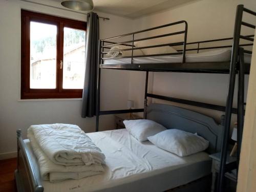 une chambre avec deux lits superposés avec des draps blancs dans l'établissement appartement du Pont des Fées, à Gérardmer