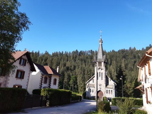 Une église avec une cloche au milieu d'une rue dans l'établissement appartement du Pont des Fées, à Gérardmer