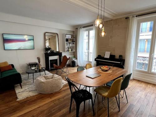 un salon avec une table et un piano dans l'établissement Design flat for 4 people Paris 18 close to Montmartre, à Paris