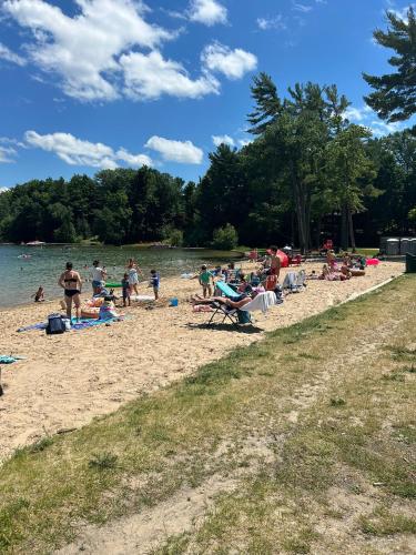 a group of people on a beach near the water at LONG LAKE RETREAT- Hot tub, Pool table, Firepit in Traverse City