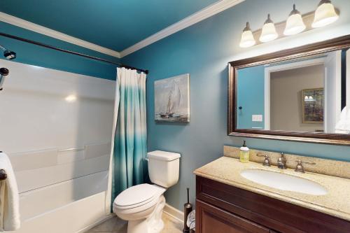a bathroom with a toilet and a sink and a mirror at The Marlin in Arden