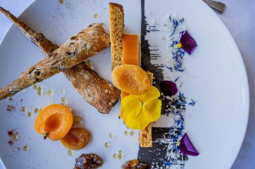 a white plate with food on it with orange slices at Logis Hôtel Le Régal & Spa in Saint Die
