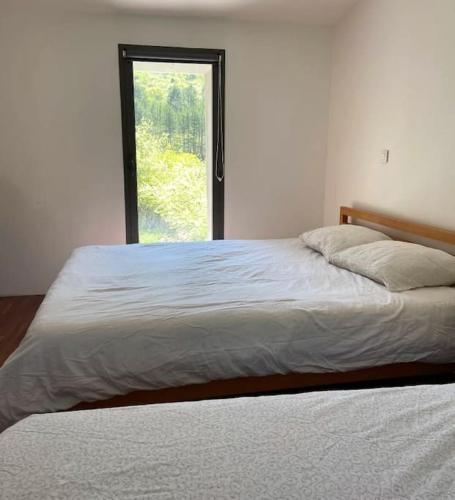 une chambre avec un grand lit avec une fenêtre dans l'établissement Espace Bergerie La maison d'Hélène, à Peille