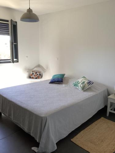 une chambre avec un grand lit avec des oreillers bleus dessus dans l'établissement Casa Laurel, à Figari