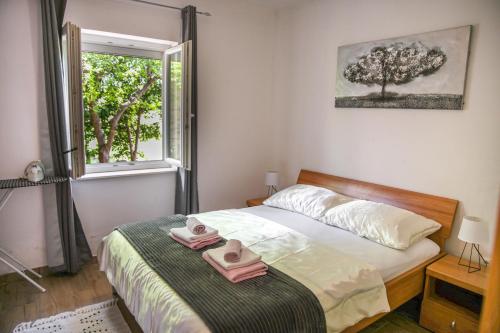 a bedroom with a bed with two towels on it at Apartments Maris in Vinišće