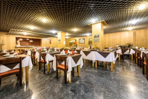 a restaurant with tables and chairs in a room at Hotel Schenatti in Sondrio