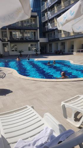 a swimming pool with some people in the water at Прекрасно студио in Sunny Beach
