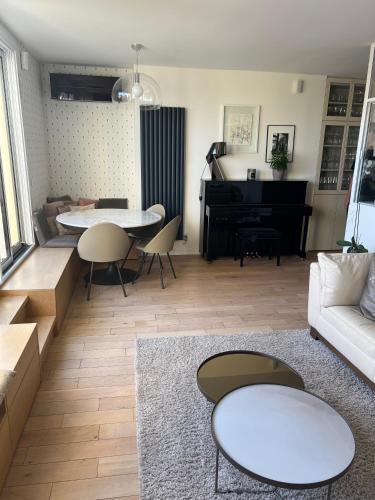 - un salon avec un canapé et un piano dans l'établissement Magnifique appartement Terrasse Paris, à Paris