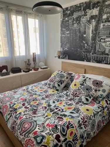 une chambre avec un lit avec une couette colorée dans l'établissement Magnifique appartement Terrasse Paris, à Paris