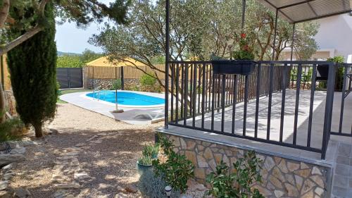 a fence with a pool in a yard at M&S Paradise Bilice, Šibenik in Vrulje