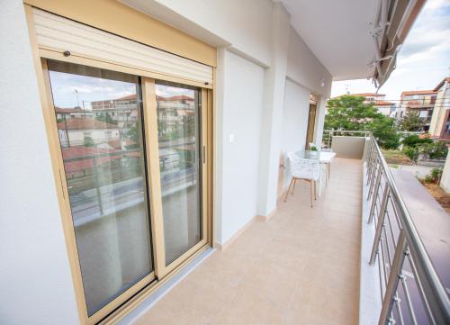 a balcony with sliding glass doors and a table at Fay's Apartment in Nea Vrasna