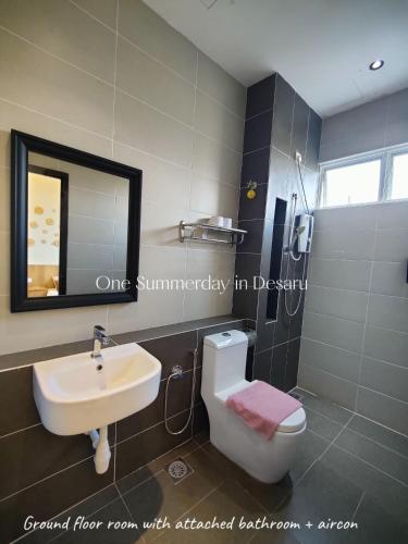 a bathroom with a sink and a toilet and a mirror at One Summerday in Desaru in Kangkar Chemaran