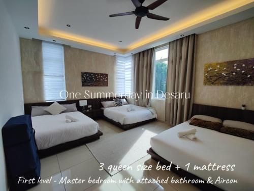 a bedroom with two beds and a ceiling fan at One Summerday in Desaru in Kangkar Chemaran