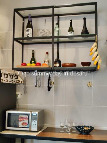 a kitchen with a counter with a microwave and some bottles at One Summerday in Desaru in Kangkar Chemaran
