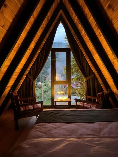 a bedroom with a bed and a large window at ZeRa Suit Bungalov Rize in Ardeşen