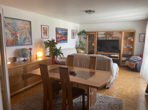 un salon avec une table à manger et un salon avec une télévision dans l'établissement Apt 2 pièces, vue admirable, localisation exceptionnelle à 20 mn de Paris, à Noisy-le-Grand