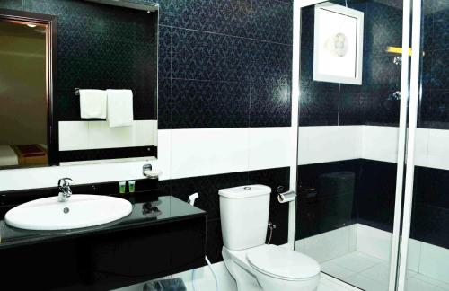 a bathroom with a toilet and a sink and a shower at Aryana Hotel in Al Buraymī
