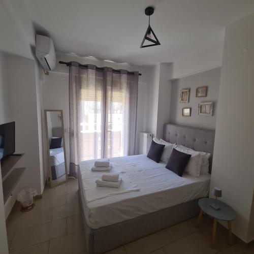 a bedroom with a white bed and a window at FREE PRIVATE PARKING # MAGENTA RUBY # DTerra Apartments in Thessaloniki