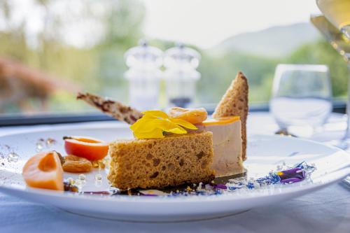 a piece of cake on a plate on a table at Logis Hôtel Le Régal & Spa in Saint Die