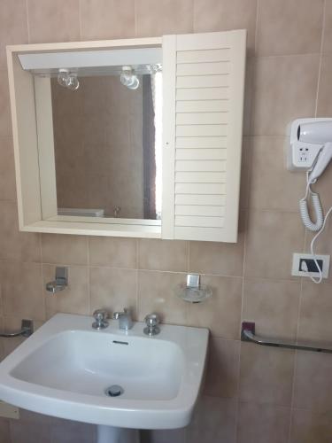 une salle de bain avec un lavabo blanc et un miroir dans l'établissement Locanda In Montagna Da Emili&Gabriel, à Lizzano in Belvedere