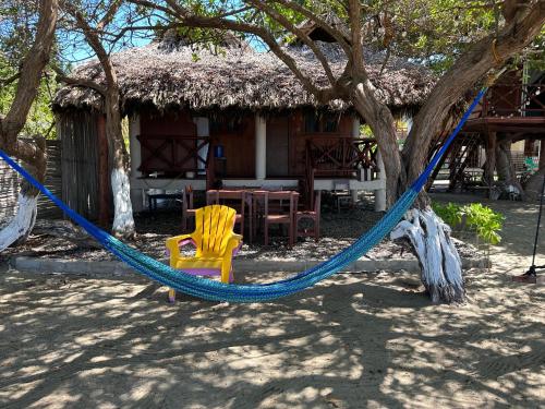 a blue hammock in front of a house at Cabañas Dobles Barra la Saladita in La Salada