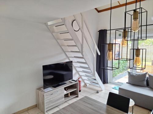 a living room with a tv and a staircase at Hippodroom 6 in Bredene