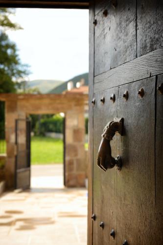 an open wooden door with a horse handle on it at Posada La Torre de La Quintana in Liendo
