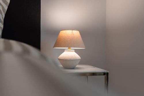 a lamp sitting on a table next to a bed at Sea Front - Spacious - Beautiful in Sliema