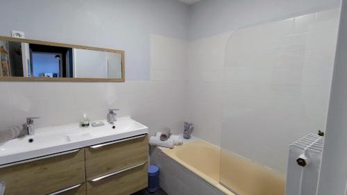 une salle de bain blanche avec un lavabo et une baignoire dans l'établissement Votre logement de Herault - Montpellier Celleneuve, à Montpellier