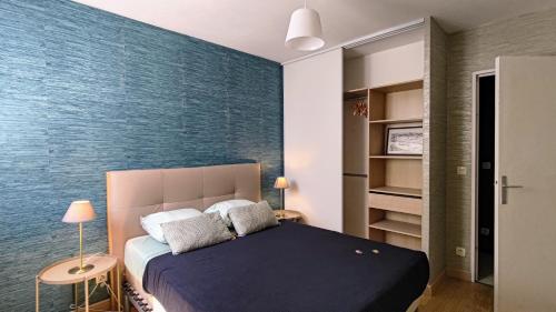 - une chambre dotée d'un lit avec un mur bleu dans l'établissement Votre logement de Herault - Montpellier Celleneuve, à Montpellier