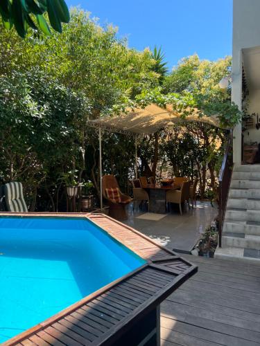 une piscine avec une table et un parasol dans l'établissement Garden pool Beach rest secure, à La Ciotat