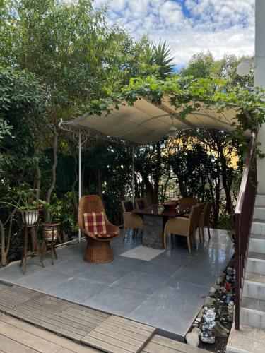 Un patio con una mesa y sillas bajo una sombrilla. en Garden pool Beach rest secure, en La Ciotat