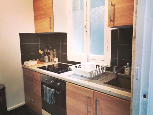 une cuisine avec un évier et un plan de travail dans l'établissement Appartement Paris 16 proche à 20 minutes de la Tour Eiffel, à Paris