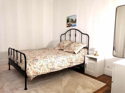 une chambre avec un lit dans une pièce avec une table de chevet dans l'établissement Appartement Paris 16 proche à 20 minutes de la Tour Eiffel, à Paris