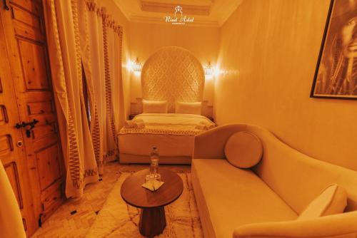 a living room with a bed and a couch at Riad Aslal in Marrakech